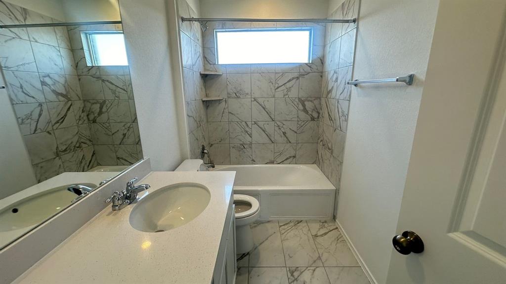 192 Rodney Boat Road Kyle, TX 78640 - Photo 20 of 38 A well-appointed bathroom features a bathtub and shower combination with striking tiled walls.