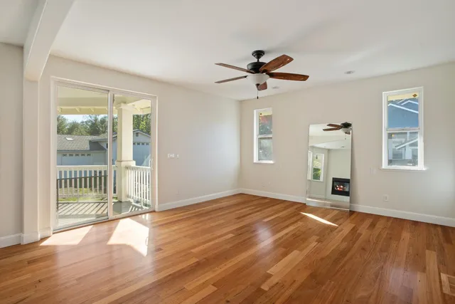 a view of a livingroom with wooden floor and a ceiling fan