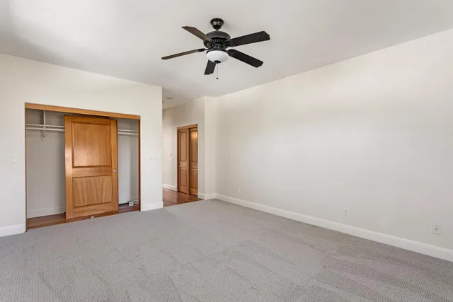 a view of an empty room and a ceiling fan
