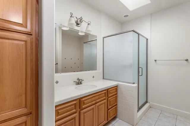 a bathroom with a shower sink and mirror