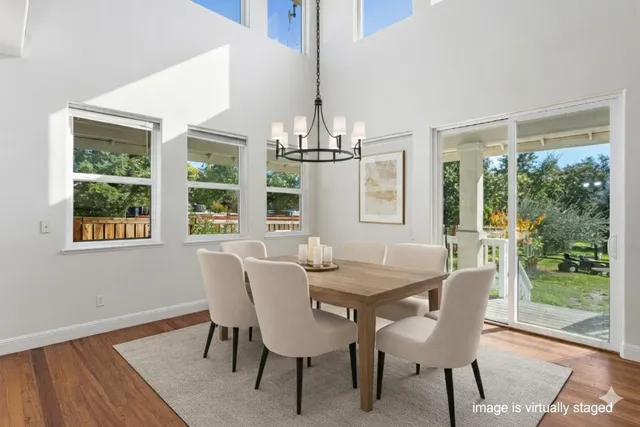 a dining room with furniture a chandelier and wooden floor