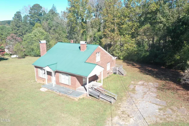 an aerial view of a house with swimming pool and big yard