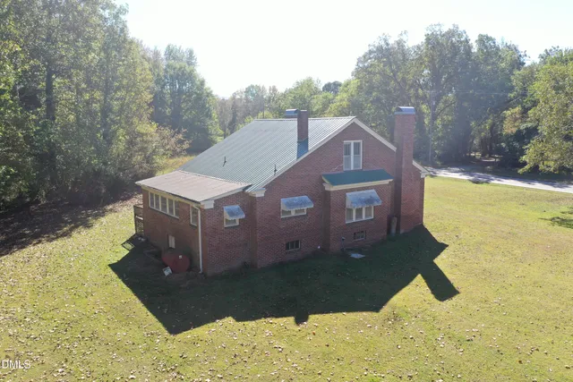 a aerial view of a house next to a yard with a large tree