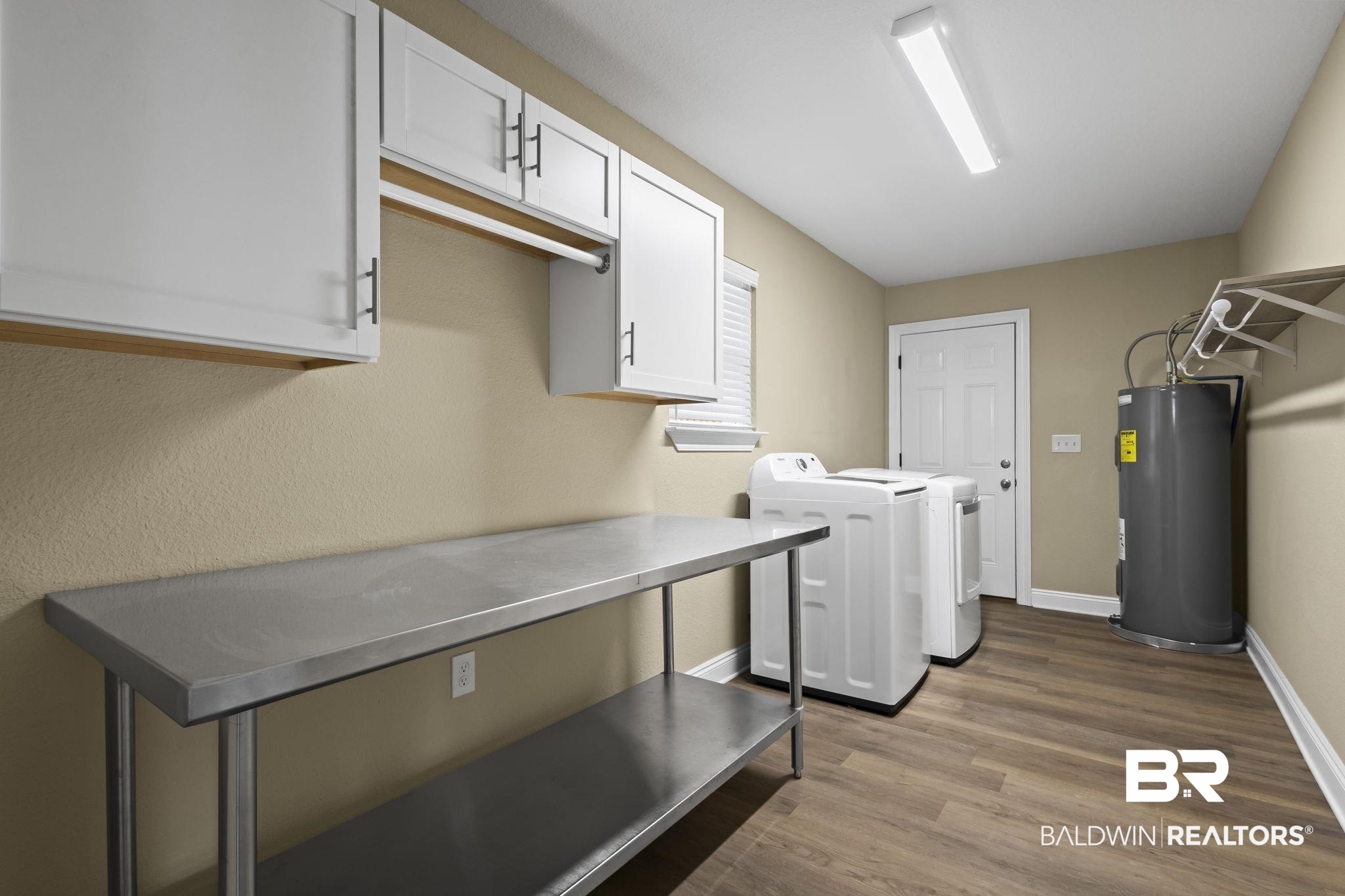 8781 Baptist Camp Road Elberta, AL 36530 - Photo 17 of 44 Washroom featuring dark wood finished floors, washing machine and clothes dryer, cabinet space, water heater, and baseboards