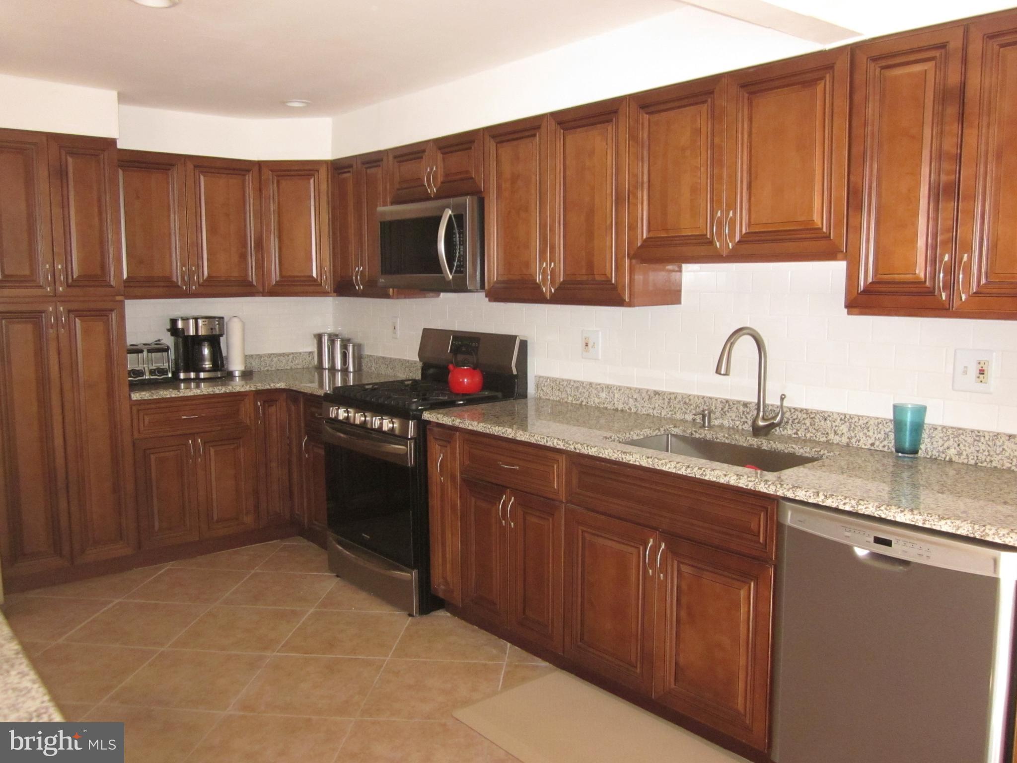 11605 Stevens Road Philadelphia, PA 19116 - Photo 11 of 44 a kitchen with stainless steel appliances granite countertop a sink dishwasher stove and cabinets with wooden floor