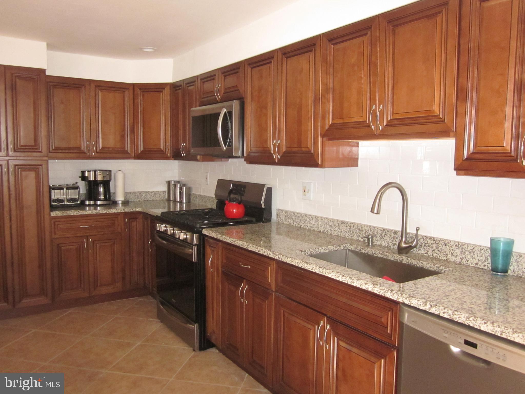 11605 Stevens Road Philadelphia, PA 19116 - Photo 13 of 44 a kitchen with granite countertop a sink stainless steel appliances and cabinets