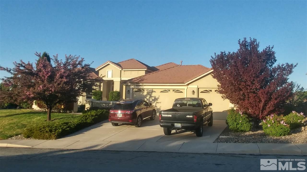 a front view of a house with cars parked