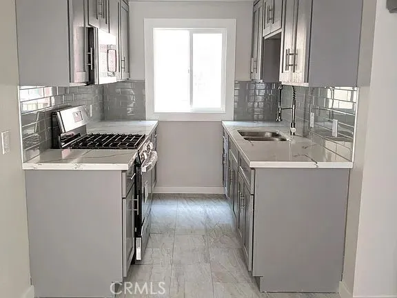 a kitchen with a sink stove and cabinets