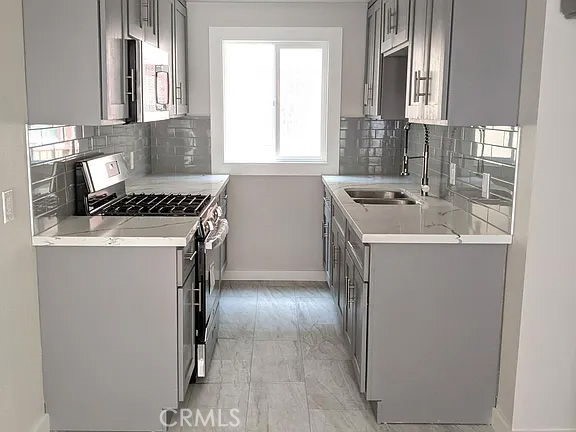 7370 Neo Street Downey, CA 90241 - Photo 23 of 38 a kitchen with a sink stove and cabinets