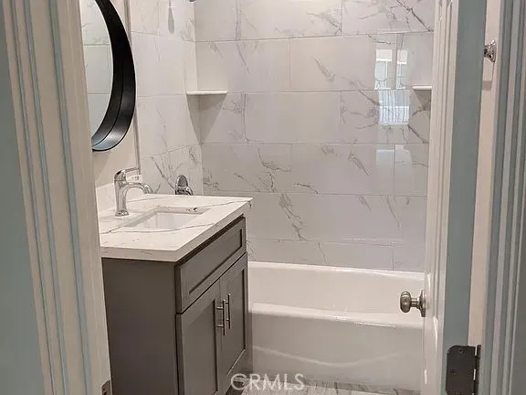 a bathroom with a granite countertop sink a mirror and shower