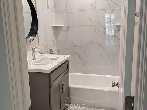 7370 Neo Street Downey, CA 90241 - Photo 24 of 38 a bathroom with a granite countertop sink a mirror and shower