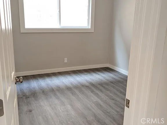 7370 Neo Street Downey, CA 90241 - Photo 28 of 38 an empty room with wooden floor and windows