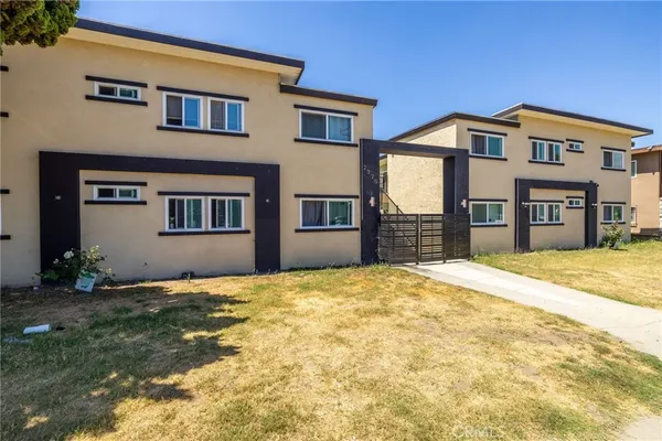 a view of an house with backyard and a tree
