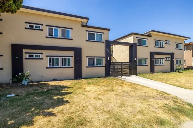 a view of an house with backyard and a tree