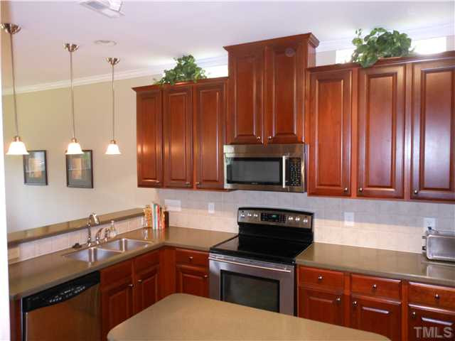 3414 Ranbir Drive Durham, NC 27713 - Photo 4 of 21 a kitchen with kitchen island granite countertop wooden cabinets a stove top oven a sink and dishwasher