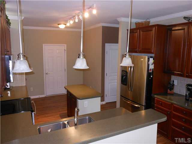 3414 Ranbir Drive Durham, NC 27713 - Photo 7 of 21 a kitchen with kitchen island a counter top space a sink stainless steel appliances and cabinets