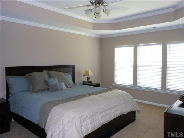 3414 Ranbir Drive Durham, NC 27713 - Photo 8 of 21 a bedroom with a large bed and a chandelier