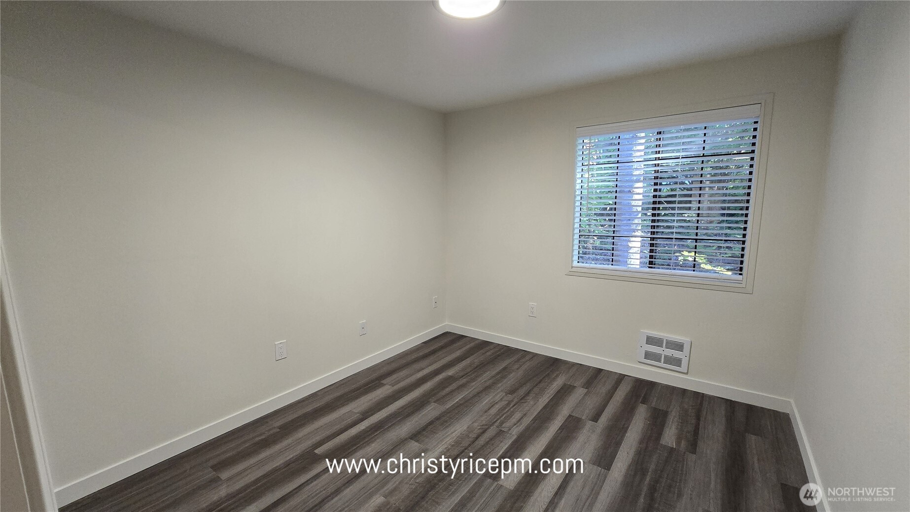 12515 Northeast 116th Street, Unit B23 Kirkland, WA 98034 - Photo 11 of 17 a view of an empty room with wooden floor and a window