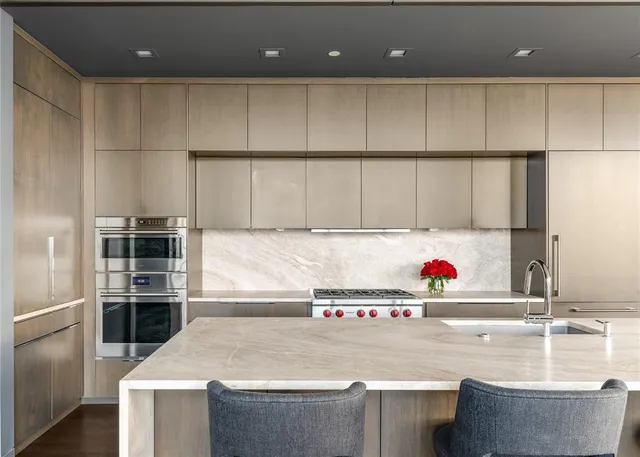 a kitchen with kitchen island a sink a stove and a refrigerator
