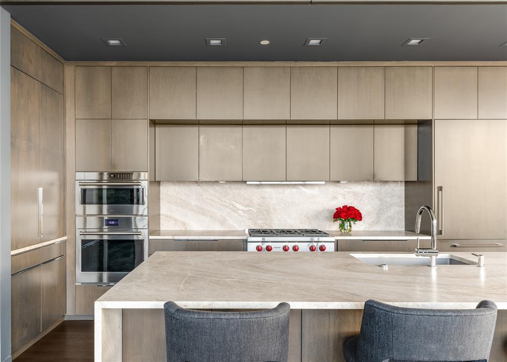 1918 Olive Street, Unit 3403 Dallas, TX 75201 - Photo 6 of 39 a kitchen with kitchen island a sink a stove and a refrigerator