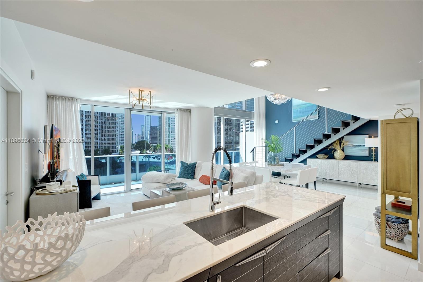 200 Biscayne Blvd Way, Unit 505 Miami, FL 33131 - Photo 15 of 51 a kitchen with stainless steel appliances kitchen island granite countertop a sink and a refrigerator