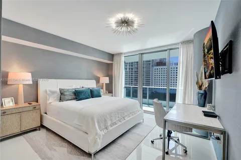 a bedroom with bed and a chandelier