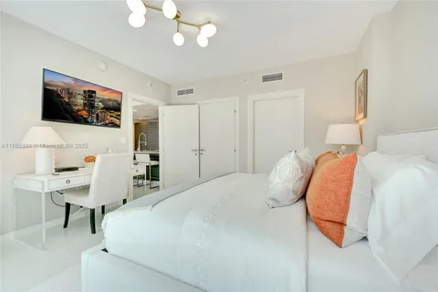 a bedroom with a bed and a flat screen tv