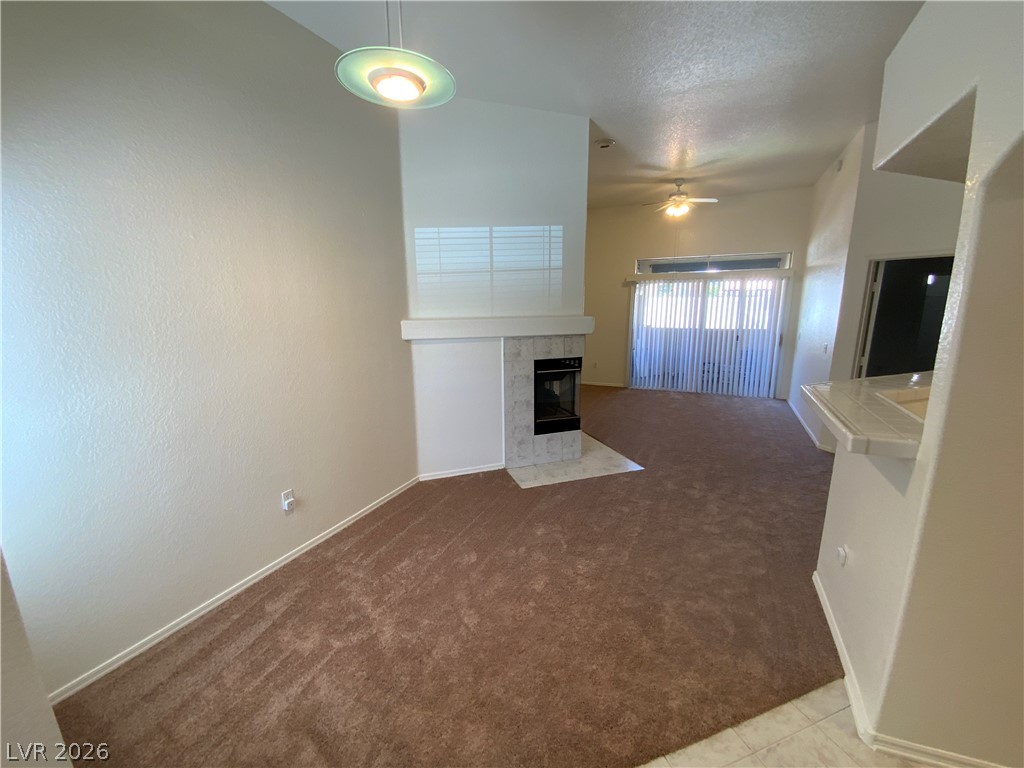 7400 West Flamingo Road, Unit 1039 Las Vegas, NV 89147 - Photo 7 of 40 A welcoming living space features a cozy fireplace and convenient sliding door access to the outdoors.
