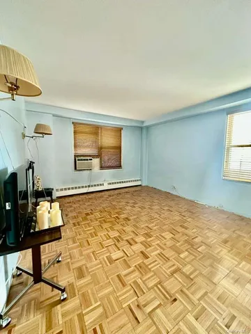 a view of a livingroom with wooden floor and furniture