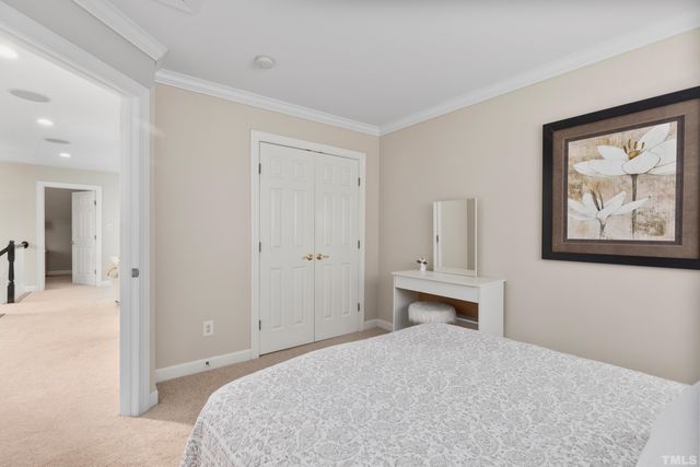 a bedroom with a bed and painting on the wall