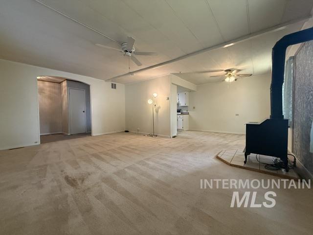 1360 Pioneer Road Weiser, ID 83672 - Photo 2 of 47 Spacious interior with neutral carpeting and a prominent wood-burning stove on a tiled hearth
