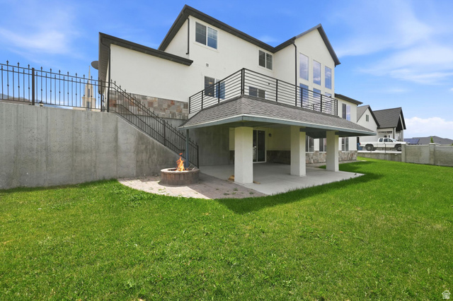 1002 West Temple Rim Lane Payson, UT 84651 - Photo 57 of 68 Expansive rear elevation featuring a covered patio, upper-level balcony with black railing, and a stone fire pit