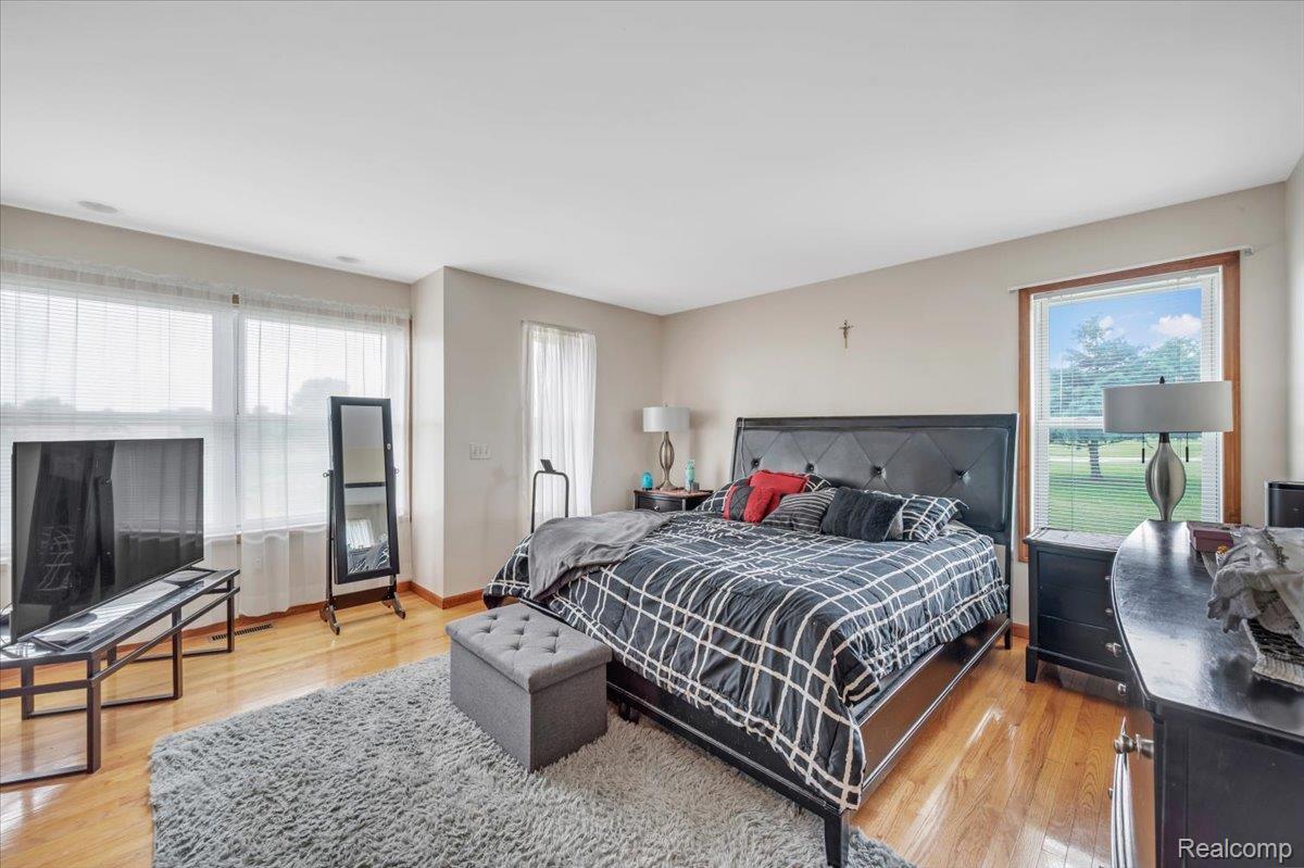 2551 Marathon Road Lapeer, MI 48446 - Photo 20 of 33 Spacious sleeping area featuring wood-finish flooring, light-colored walls, and multiple windows