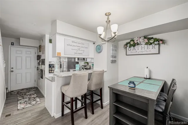a view of a dining room with furniture a chandelier and wooden floor