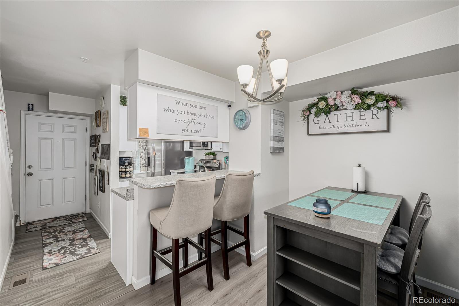 4282 Charleston Drive Colorado Springs, CO 80916 - Photo 11 of 50 a view of a dining room with furniture a chandelier and wooden floor