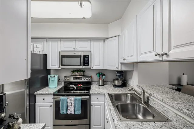 a kitchen with granite countertop a sink a stove and cabinets