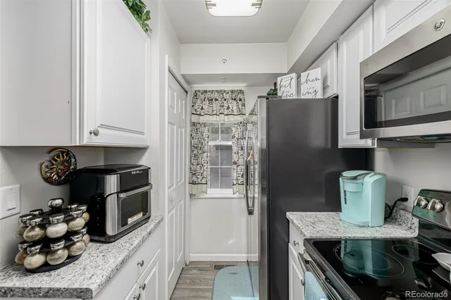 a kitchen with stainless steel appliances granite countertop a refrigerator and a stove top oven