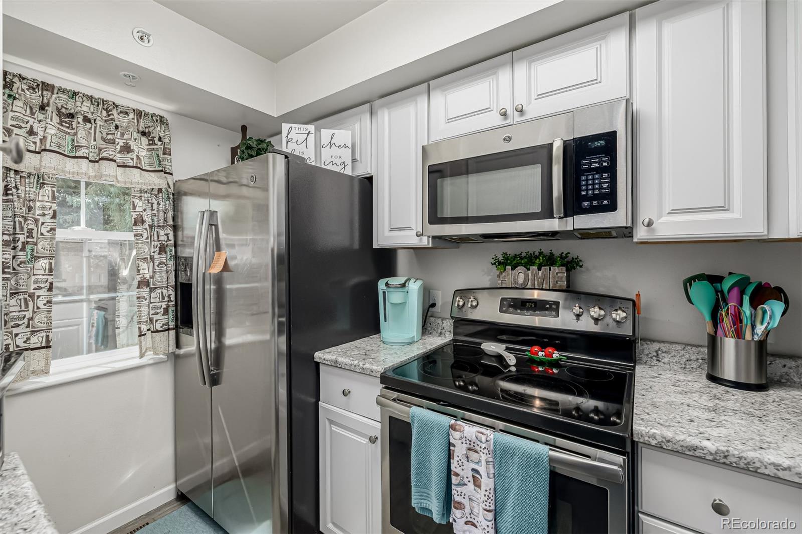 4282 Charleston Drive Colorado Springs, CO 80916 - Photo 15 of 50 a kitchen with stainless steel appliances granite countertop a stove a refrigerator and a microwave