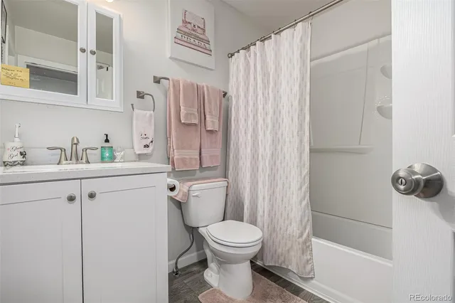 a bathroom with a granite countertop sink a toilet and shower