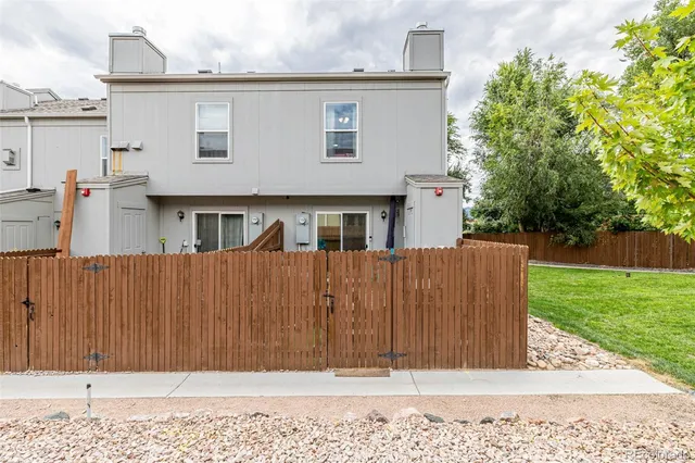 a view of a house with a wooden fence