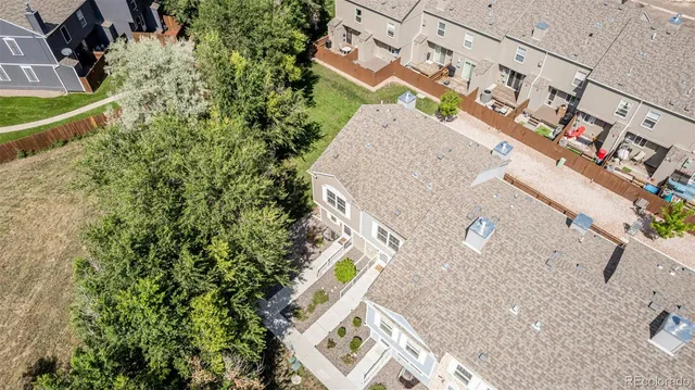 an aerial view of a house with a yard and wooden fence