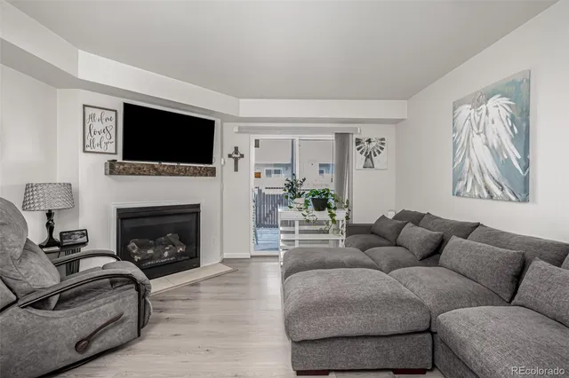 a living room with furniture a flat screen tv and a fireplace