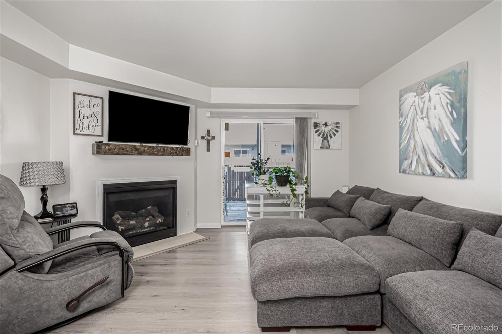 4282 Charleston Drive Colorado Springs, CO 80916 - Photo 8 of 50 a living room with furniture a flat screen tv and a fireplace