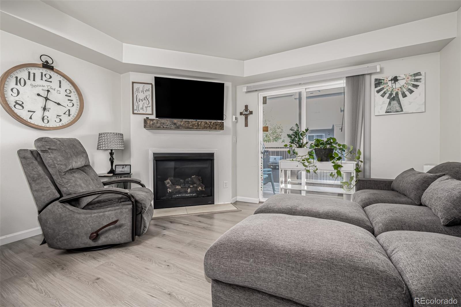 4282 Charleston Drive Colorado Springs, CO 80916 - Photo 9 of 50 a living room with furniture a flat screen tv and a fireplace