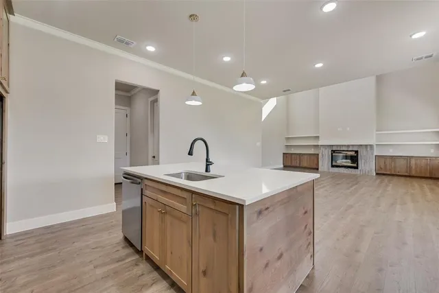 a view of a kitchen with kitchen island a sink stainless steel appliances and wooden floor
