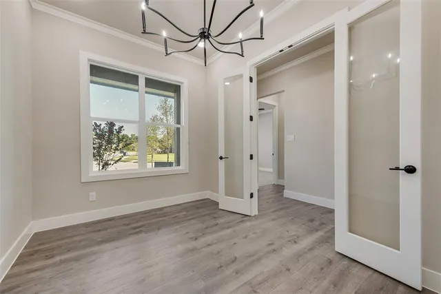 a view of hallway with window and wooden floor