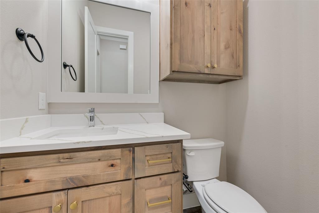 1323 Selby Road Van Alstyne, TX 75495 - Photo 19 of 38 a bathroom with a granite countertop toilet sink and mirror