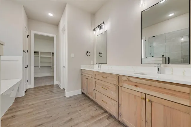 a spacious bathroom with a granite countertop sink a mirror and a shower
