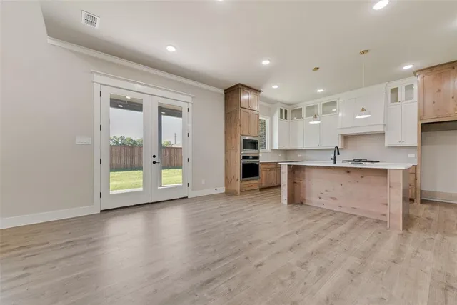 a view of kitchen with kitchen island wooden cabinets and refrigerator