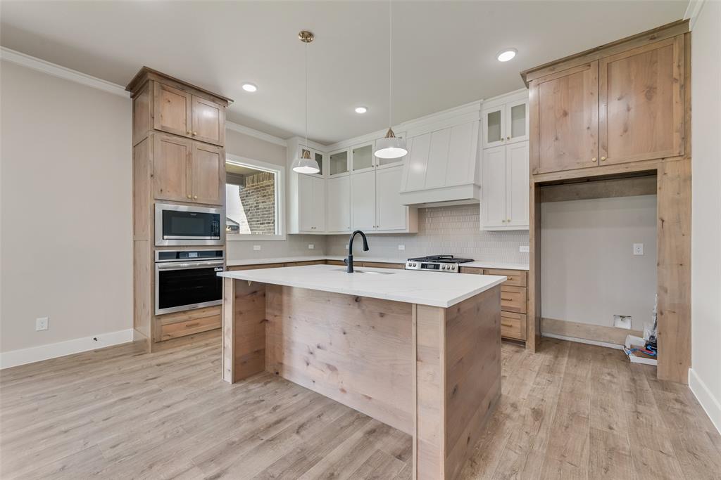 1323 Selby Road Van Alstyne, TX 75495 - Photo 7 of 38 a kitchen with kitchen island granite countertop a sink cabinets and stainless steel appliances